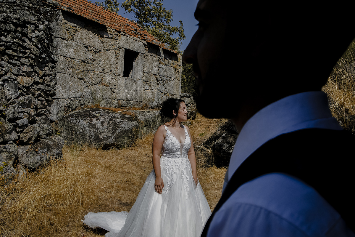 Miguel aparece em primeiro plano, dos ombros para cima em silhueta, enquanto Juliana, ao fundo, olha serenamente para o lado, ambos imersos em tranquilidade.