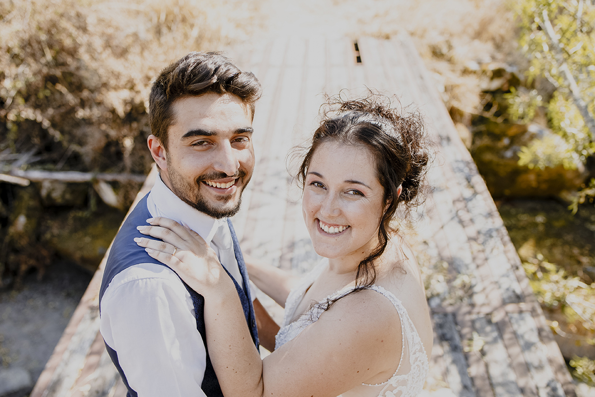 Num plano próximo e ângulo superior, o casal está frente a frente, olhando para cima em direção à câmara com sorrisos amplos, transmitindo alegria e cumplicidade.