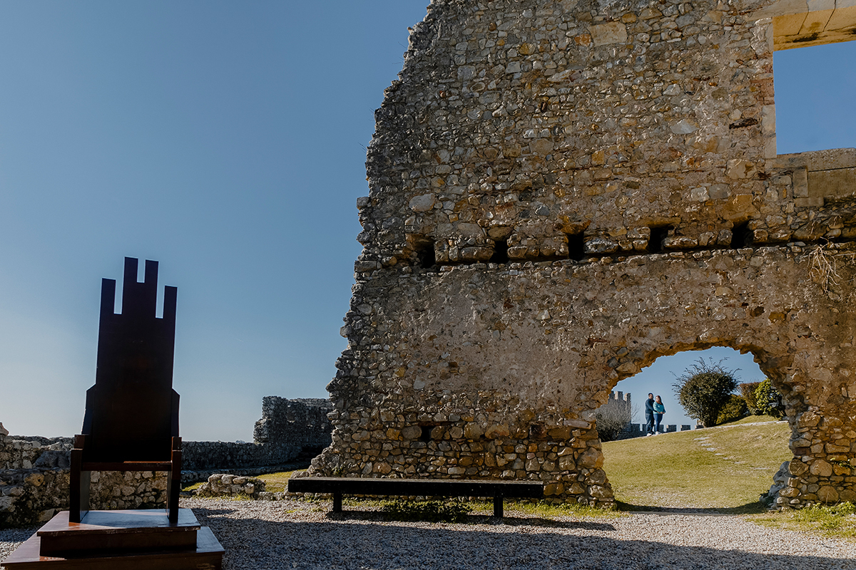 Num cenário mágico, as pedras do castelo emolduram um abraço. Ricardo envolve Mónica por trás, enquanto ela, de costas para ele, o contempla com carinho. O buraco na muralha transforma-se numa janela para o amor.