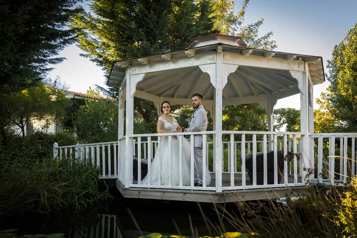 Descrição: Aqui vemos os dois em cima da ponte encostados ao corrimão os dois frente a frente, a olharem para a câmara sérios mas felizes.