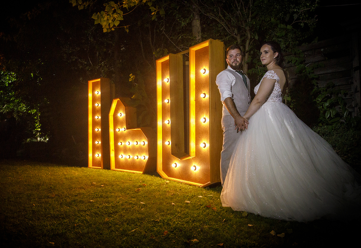 Descrição: Aqui ainda no mesmo0 cenário, na mesma posição de mãos dadas vemos os dois a olharem para a frente sérios mas felizes.