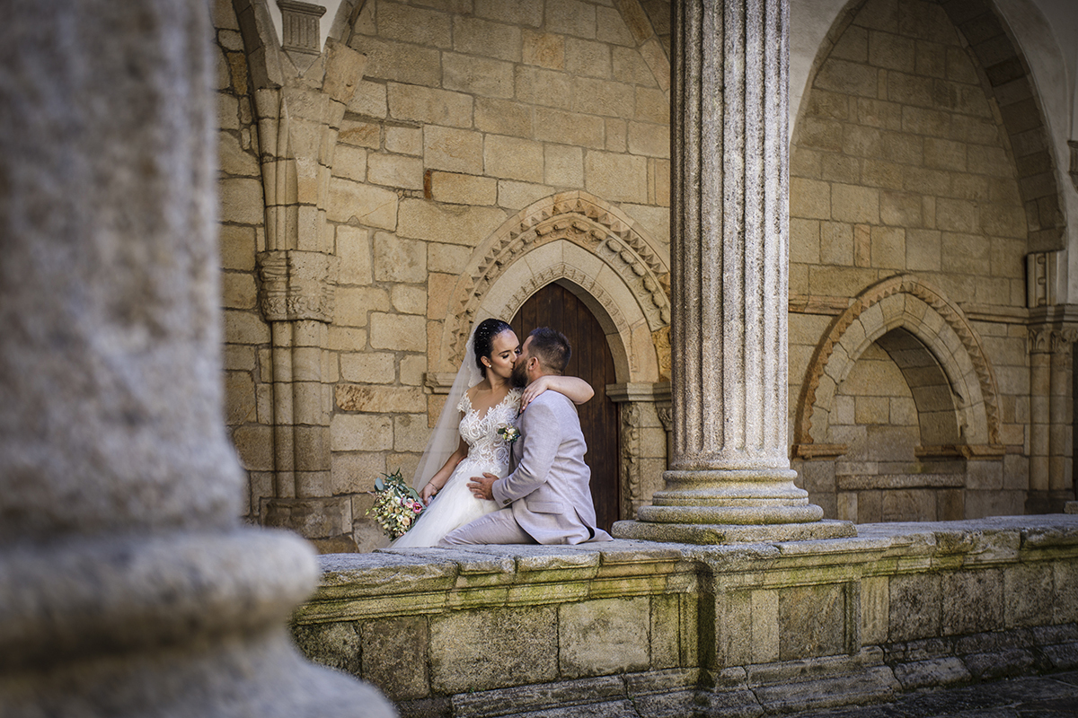 De novo no muro, Marta está sentada sobre Ricardo e os dois partilham um beijo terno enquanto ele pousa uma mão sobre a sua perna, num gesto de amor calmo e profundo, como se naquele instante o mundo inteiro parasse de girar.