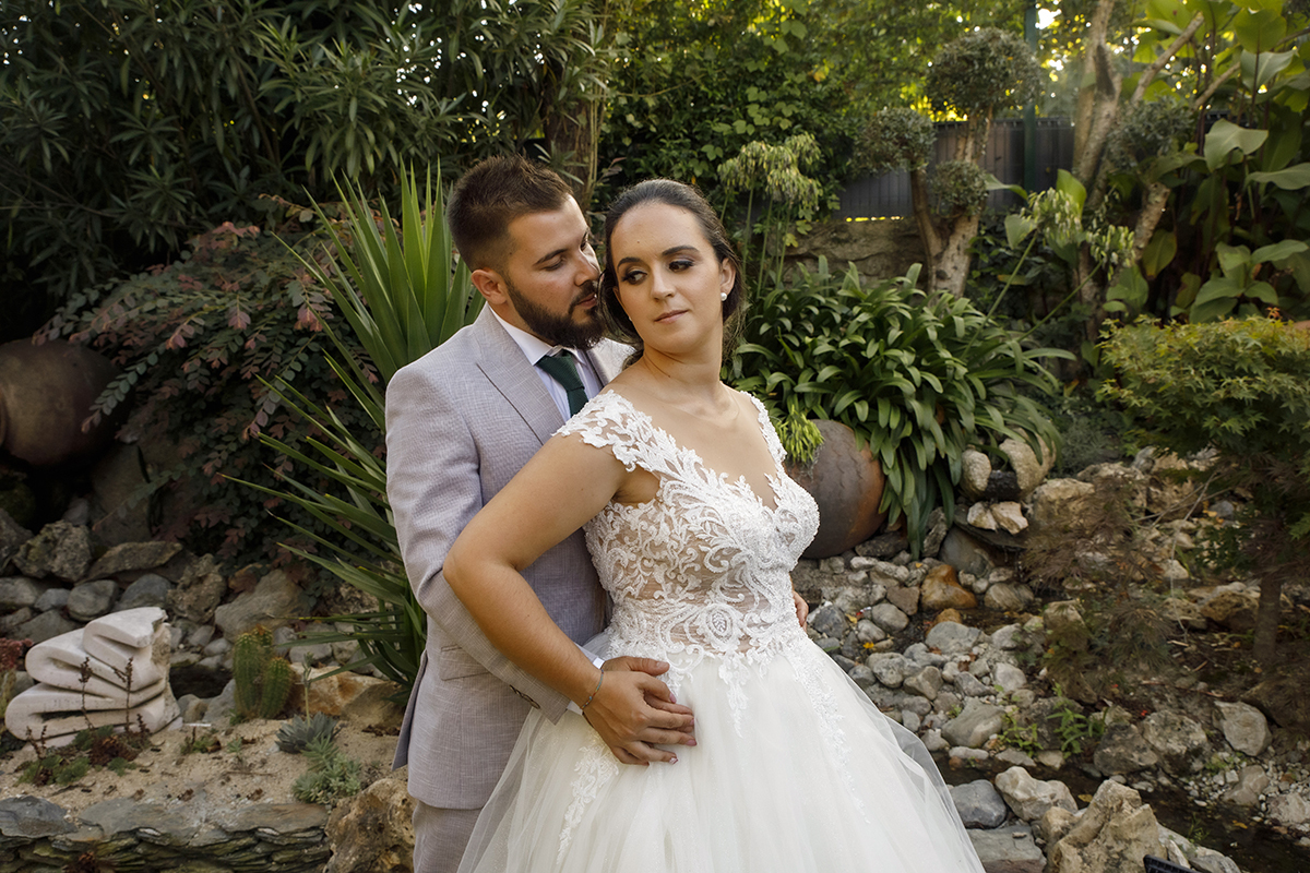 Descrição: Aqui ainda no mesmo cenário vemos o Ricardo atrás a abraçar pela cintura a Marta que está á sua frente e olha para ela fixamente e ela olha para o lado séria.