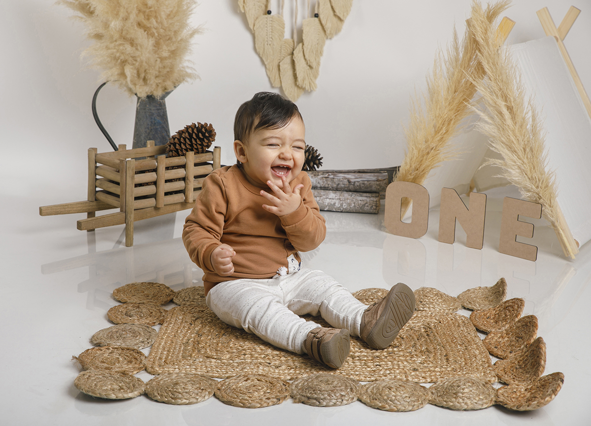 Agora o Daniel brinda-nos com uma gargalhada deliciosa! A mãozinha cobre a boca num gesto irresistível que transmite pura felicidade. O cenário continua o mesmo, mas o brilho no rosto dele rouba toda a atenção.