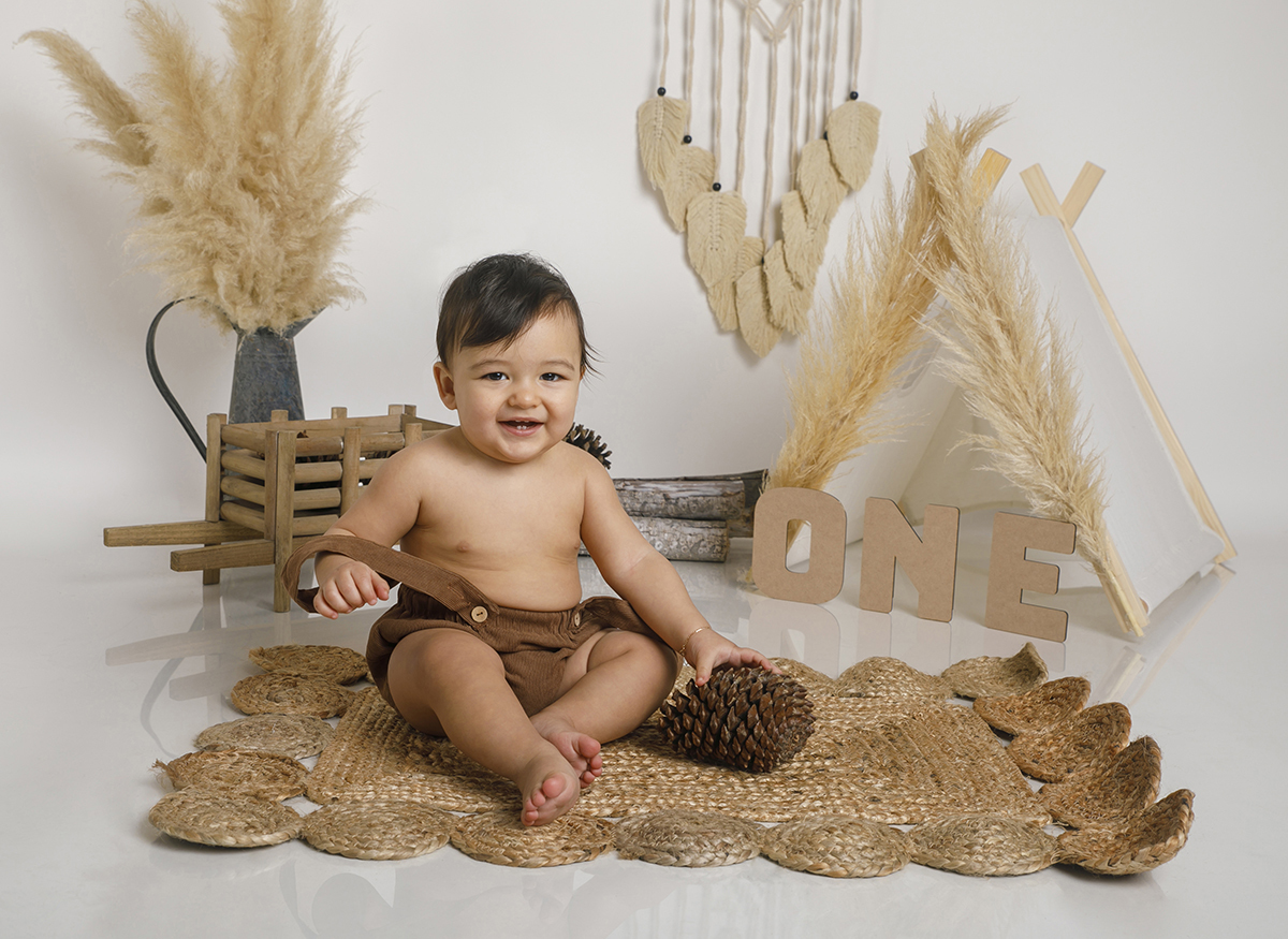 A pinha está no chão, mas Daniel continua o show. Com a mãozinha sobre ela e um sorriso gigante, ele encanta a câmara como só ele sabe fazer.