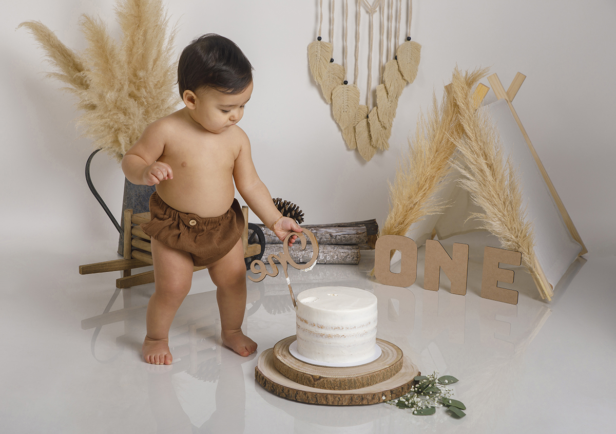 E cá está ele! Daniel em pé junto ao bolo, curioso, começa por tirar a plaquinha “ONE” como quem diz “isto é tudo meu!”