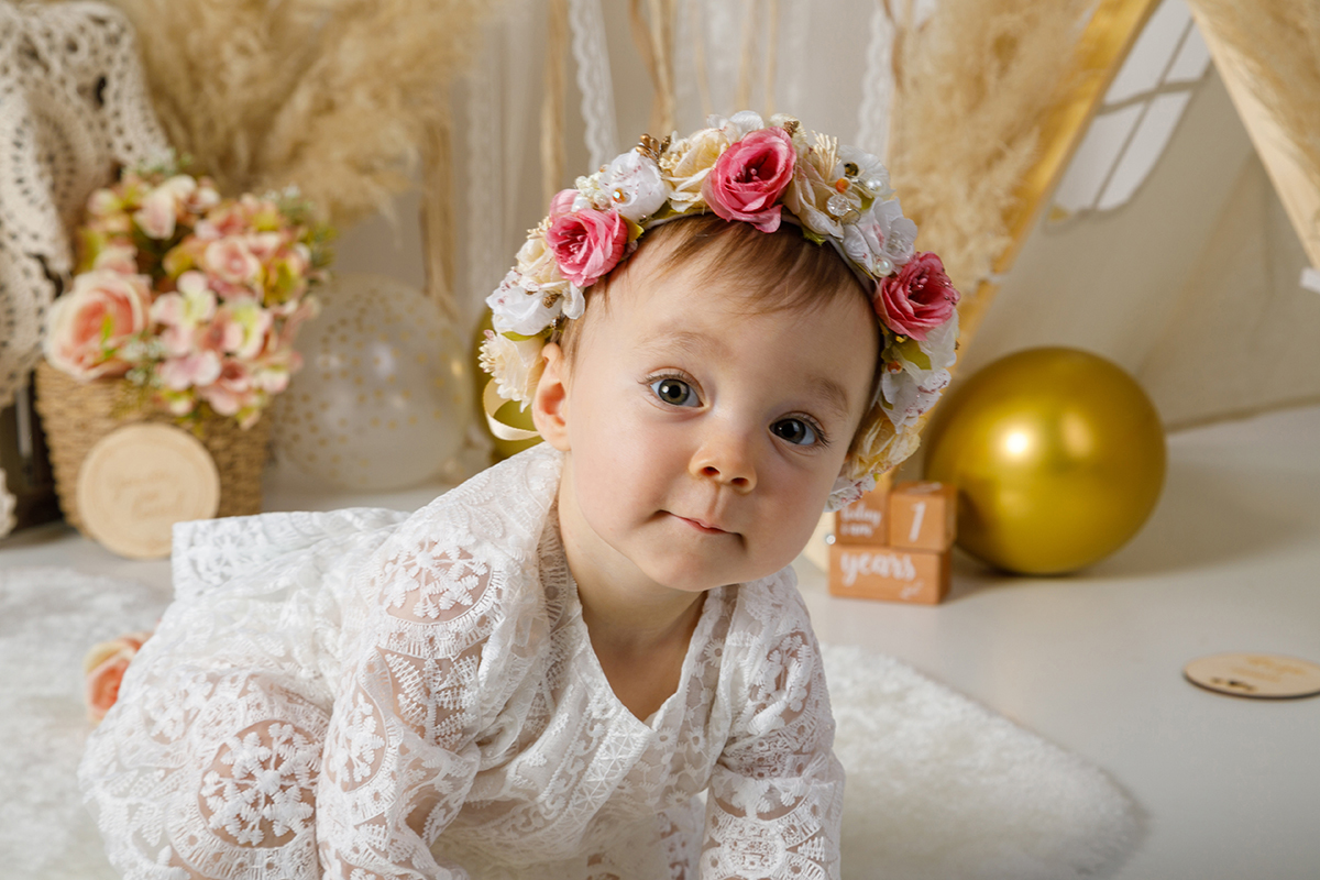 De gatas e com uma delicada coroa de flores na cabeça, Constança encara a câmara com firmeza, como quem diz: 
