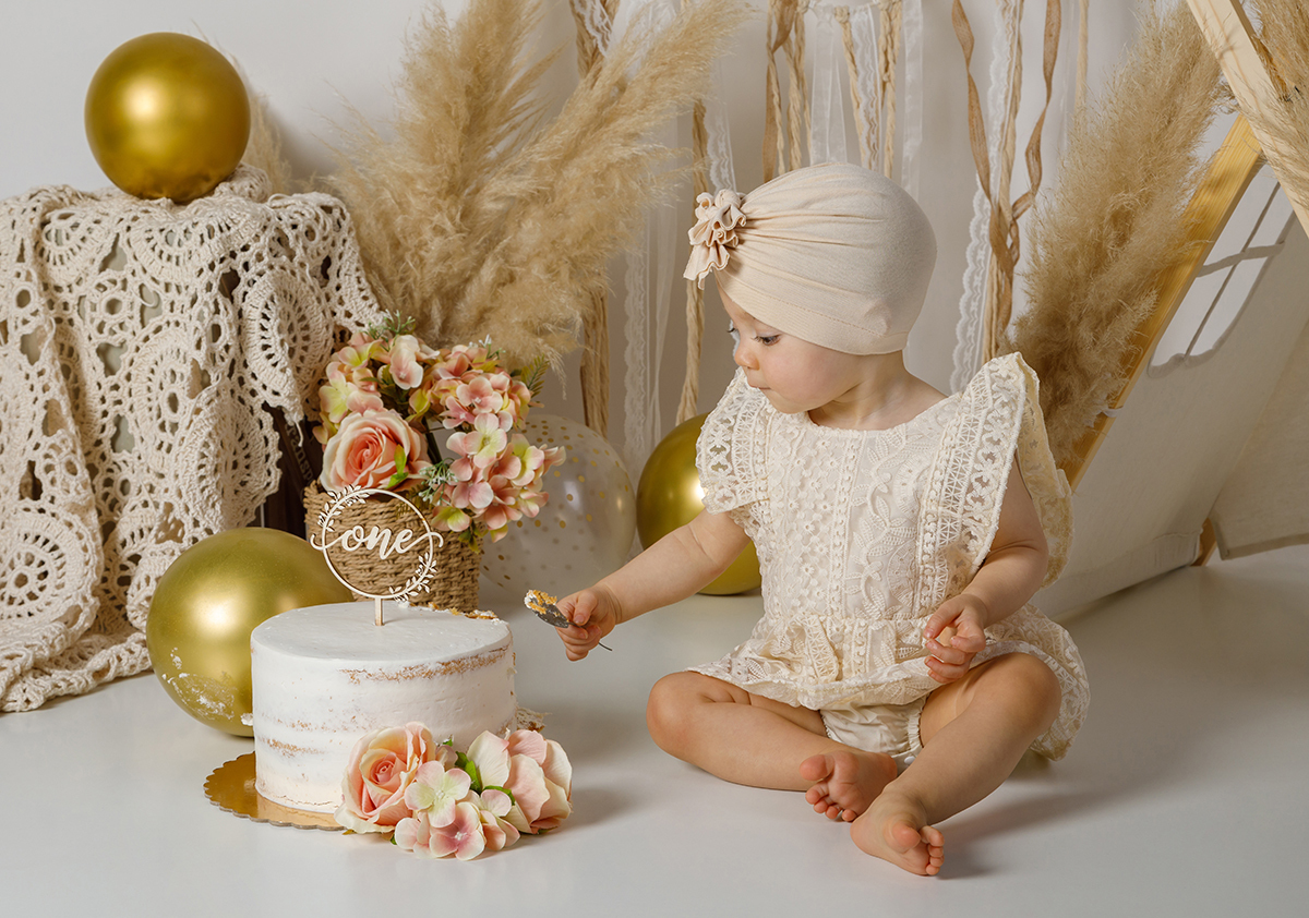 Já com uma colher na mão, a pequena aproxima-se curiosa do bolo, pronta para mergulhar nesta aventura cremosa, começa o verdadeiro Smash the Cake.