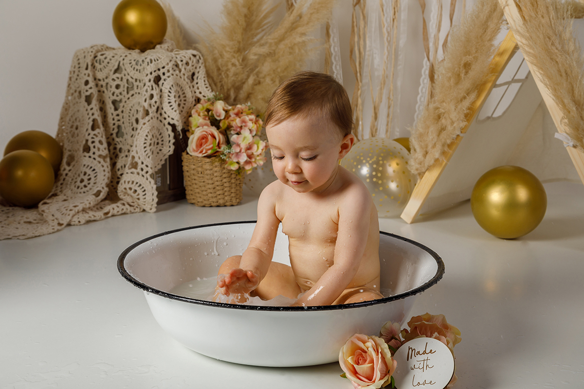 Ainda na bacia, com a cabeça mais erguida e a carinha virada para baixo, ela continua alegre a brincar com a água, encantada com cada movimento.