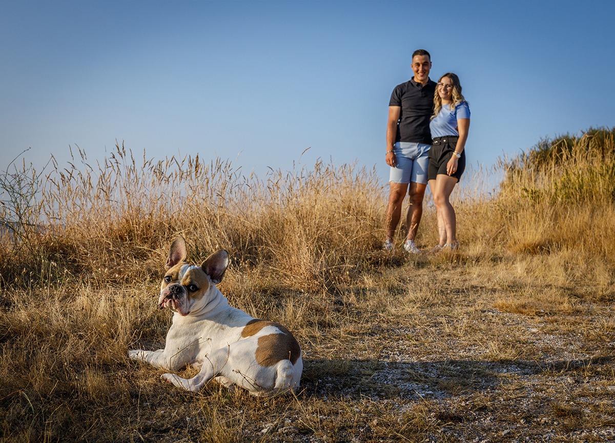 Do lado direito, os dois olham para a câmara com alegria, enquanto do lado esquerdo da imagem, o cão está deitado, também a olhar para a objetiva. Uma fotografia harmoniosa e equilibrada. Fotografia Solteiros Caramulo