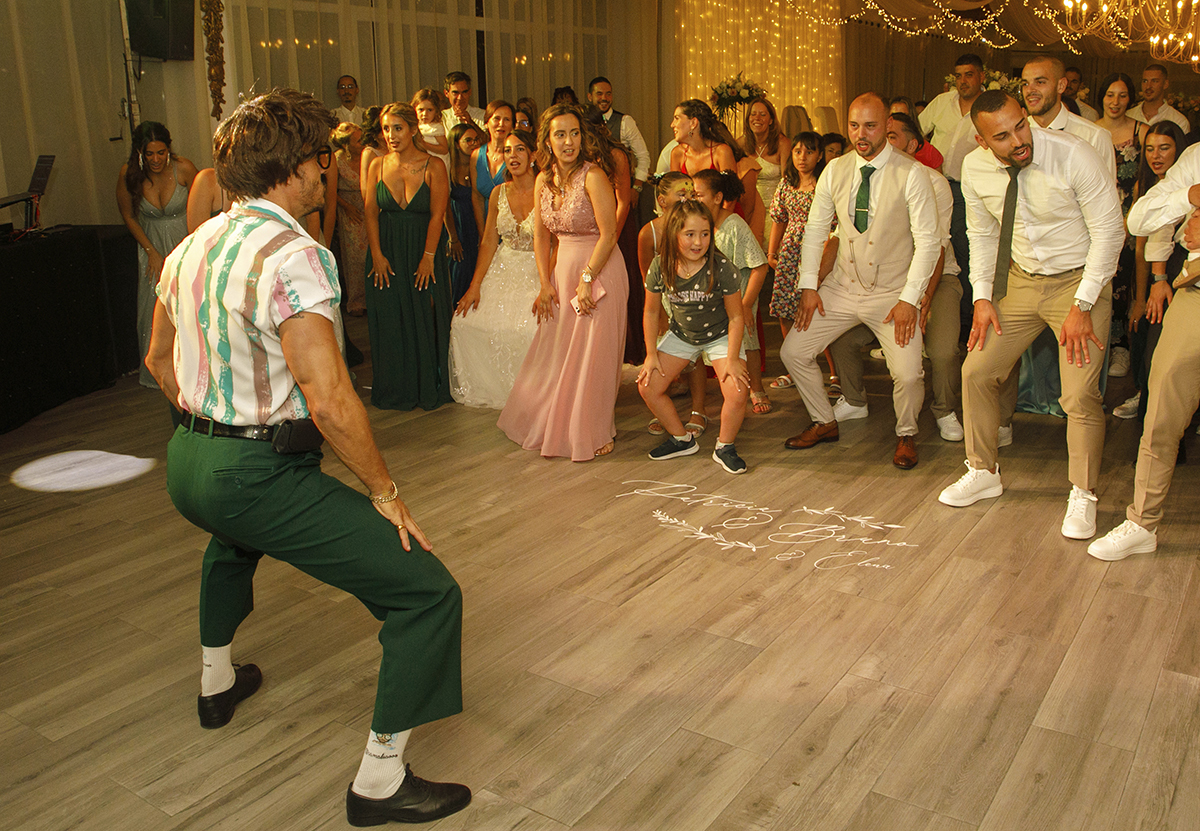 Uma coreografia de diversão: agachados, braços no ar, luzes azuis e cor-de-rosa, todos imitam o Sr. Camaleão numa energia contagiante que faz vibrar o salão.