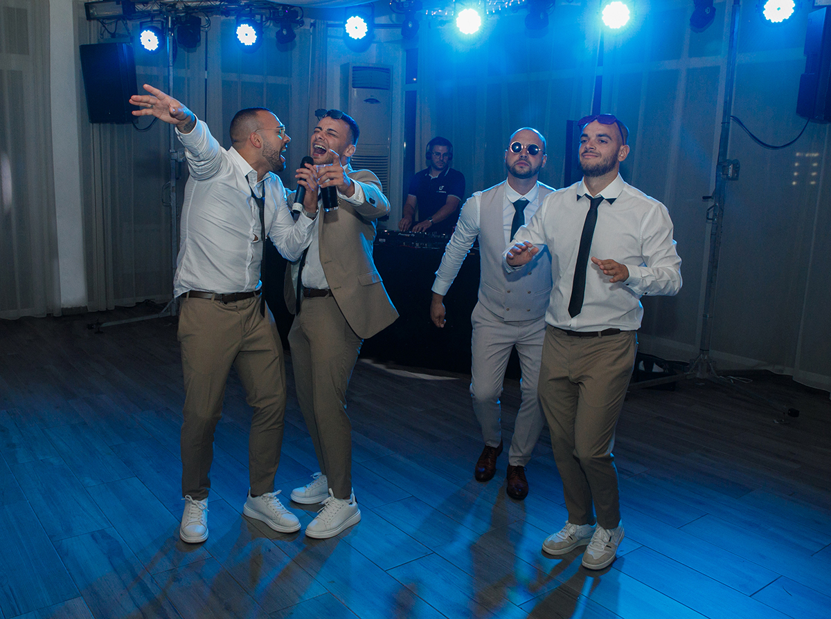 O noivo e os amigos estão a divertir-se na pista, cheios de energia e boa disposição.