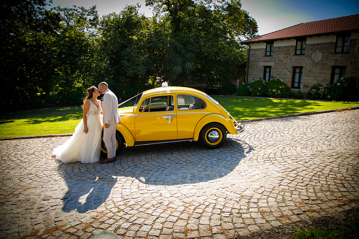 Com o Carocha ao fundo, os noivos beijam-se junto ao para-choques. A estrada e o amor, lado a lado.