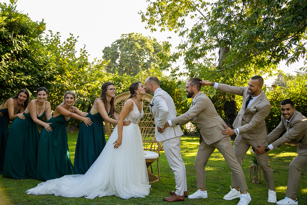 Os amigos fingem separá-los, mas nada os afasta, um beijo roubado entre gargalhadas e braços amigos.
