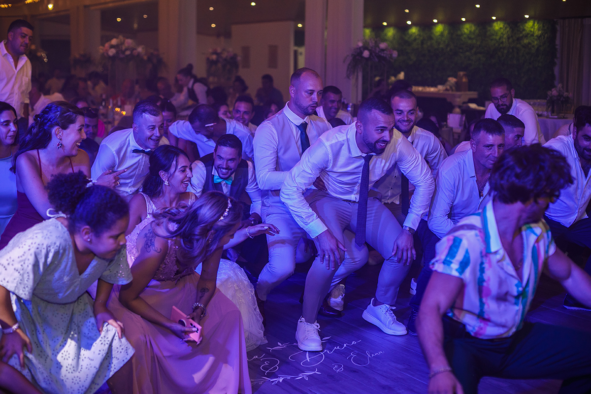 Uma coreografia de diversão: agachados, braços no ar, luzes azuis e cor-de-rosa, todos imitam o Sr. Camaleão numa energia contagiante que faz vibrar o salão.