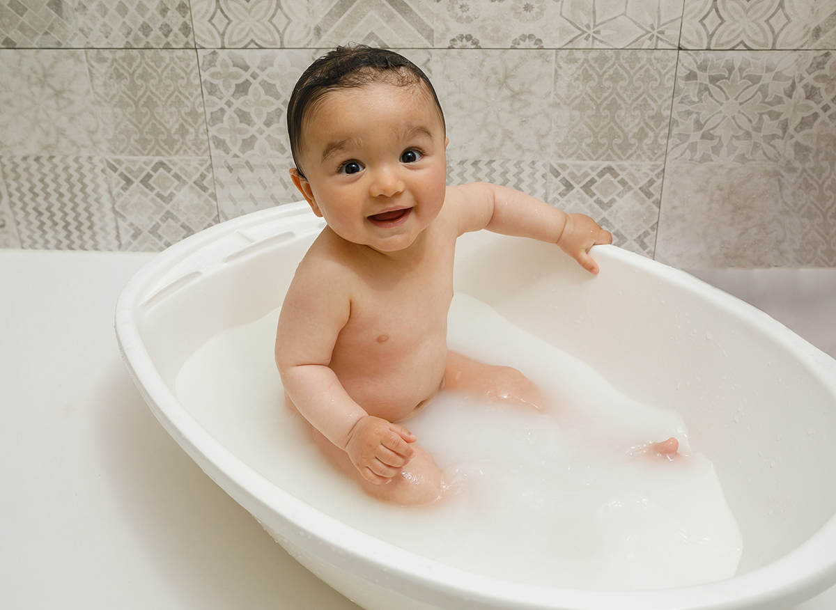 Num plano mais afastado, Francisco segura uma das bordas da bacia e olha para cima a sorrir. A luz toca-lhe o rosto com suavidade, como se a própria bênção o envolvesse naquele instante.