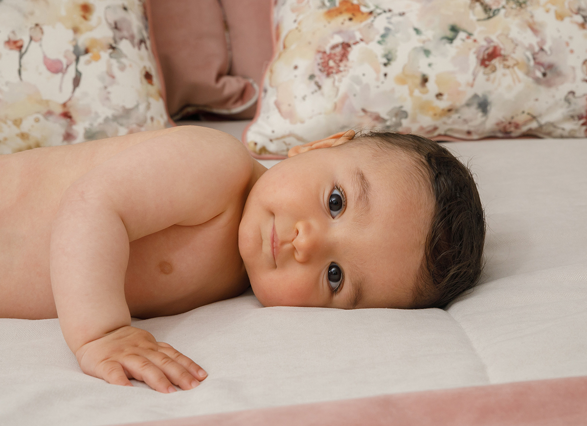 Deitado na cama, Francisco apoia-se numa mão e olha fixamente para a câmara. O brilho no olhar e a expressão serena revelam o encanto de um momento partilhado com quem o vê através da lente.