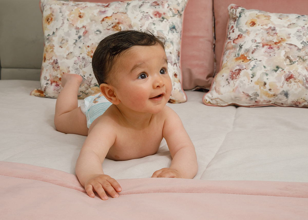 De corpo inteiro, Francisco mantém a cabeça levantada e as mãos estendidas para a frente, enquanto sorri com a alegria pura de quem descobre o mundo. As pernas levantadas e a faldrinha emolduram este retrato cheio de vida.