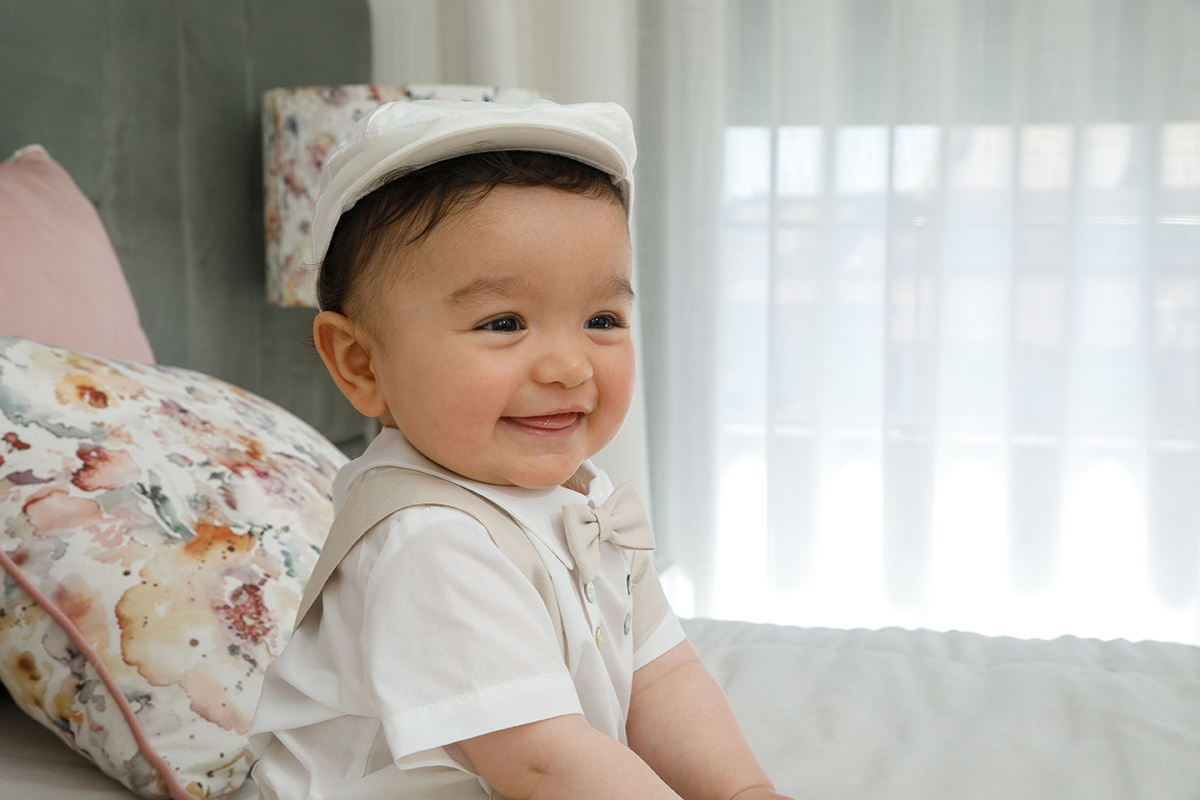 Do meio do corpo para cima, Francisco sorri ligeiramente com a língua de fora. O olhar feliz e despreocupado ilumina a imagem com inocência.