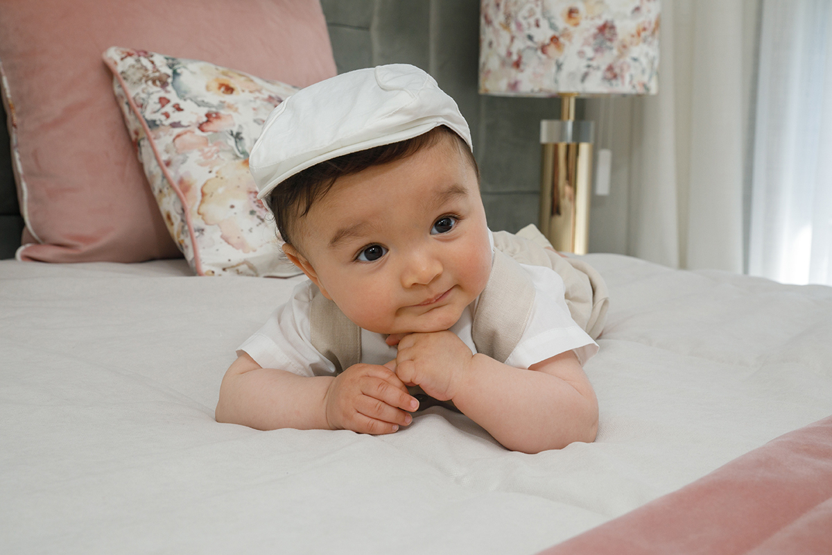 Deitado, com as mãos a segurarem o rosto, Francisco olha para o lado com seriedade e atenção. O enquadramento direto intensifica a expressão de contemplação.