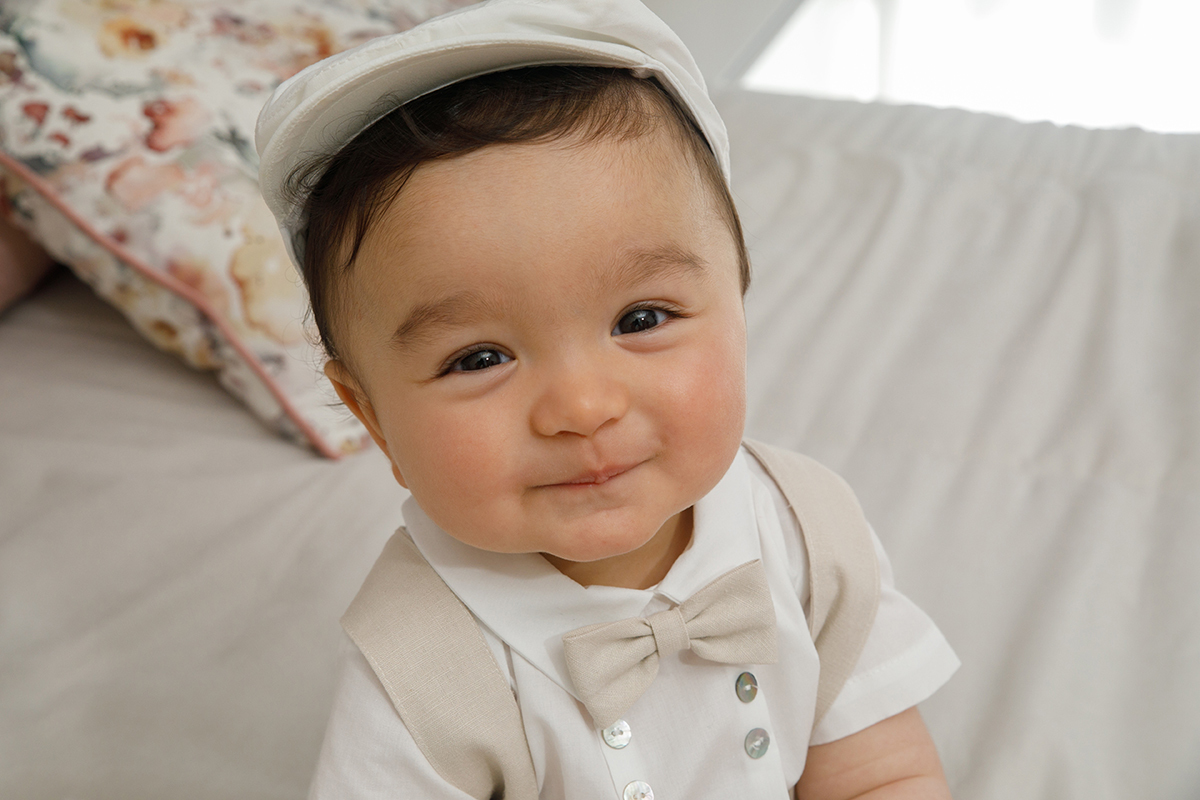 Num ângulo picado, Francisco sorri para a câmara com a boina posta. O laço bege e os botões discretamente prateados do fatinho tornam o registo ainda mais encantador.