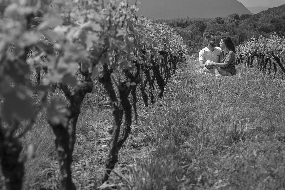 Nesta foto, também nas vinhas e a preto e branco, o casal surge no mesmo plano mas ligeiramente deslocado, permitindo ver tanto a beleza das vinhas como a ternura entre Marta e Mathieu. Reportagem cAsamento Suiça