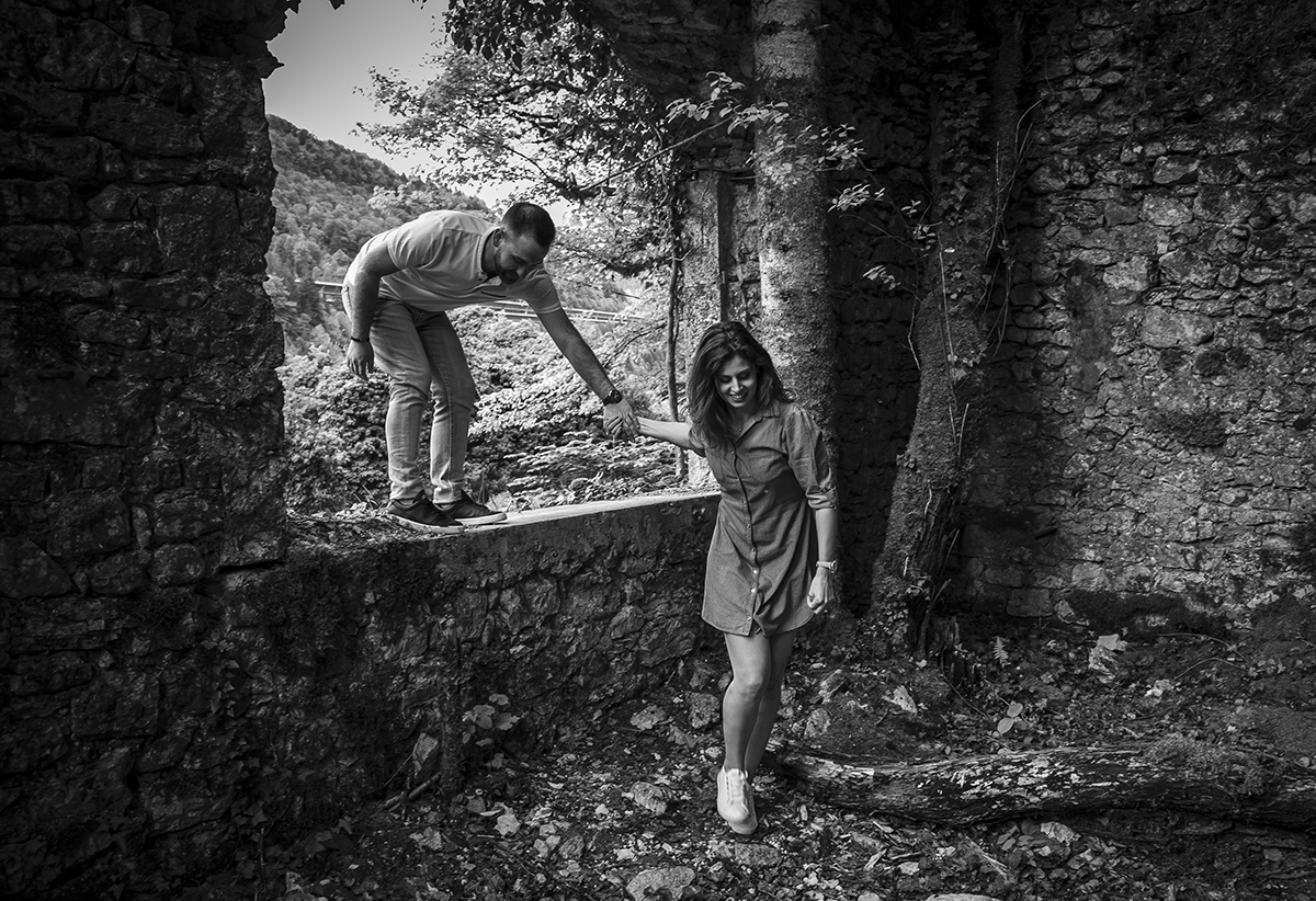 A preto e branco, Mathieu está em cima da janela e Marta em baixo, prestes a puxá-lo, como se fossem correr. Ambos têm expressões divertidas, num momento leve e cheio de brincadeira. Fotografos casamento