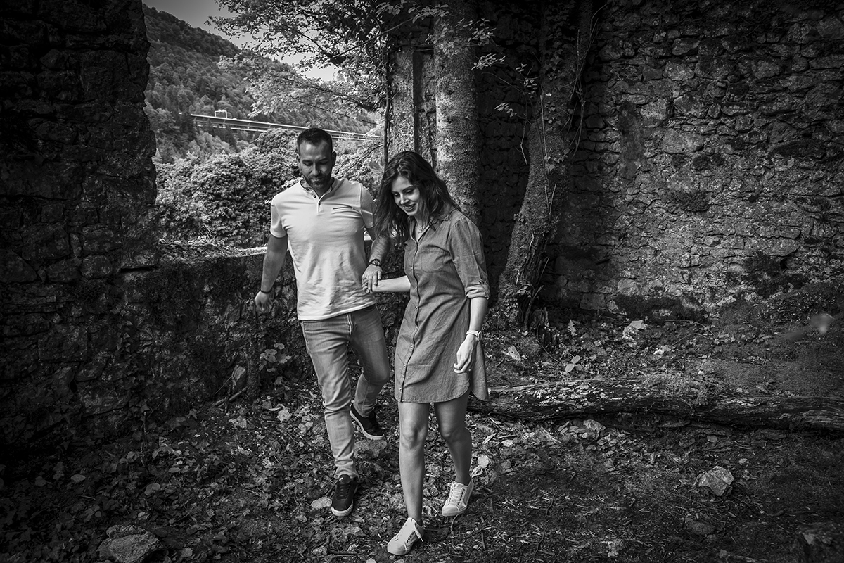 Já de volta ao chão, ainda a preto e branco, caminham de mãos dadas, trocando olhares enquanto olham para o chão. Um momento de transição, cheio de ternura.