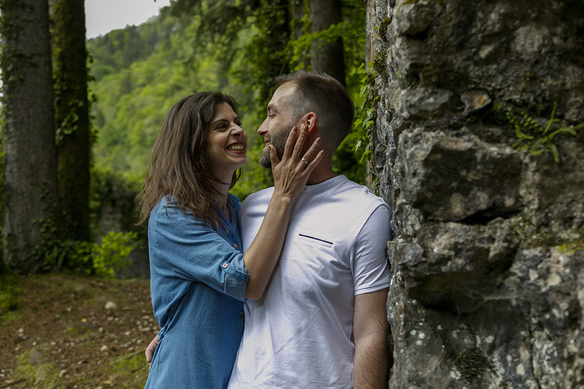 Encostados a uma parede de pedra antiga coberta de musgo, trocam um olhar profundo. Marta segura o rosto de Mathieu com uma mão, e ele envolve-a com um braço. Um momento cheio de emoção.