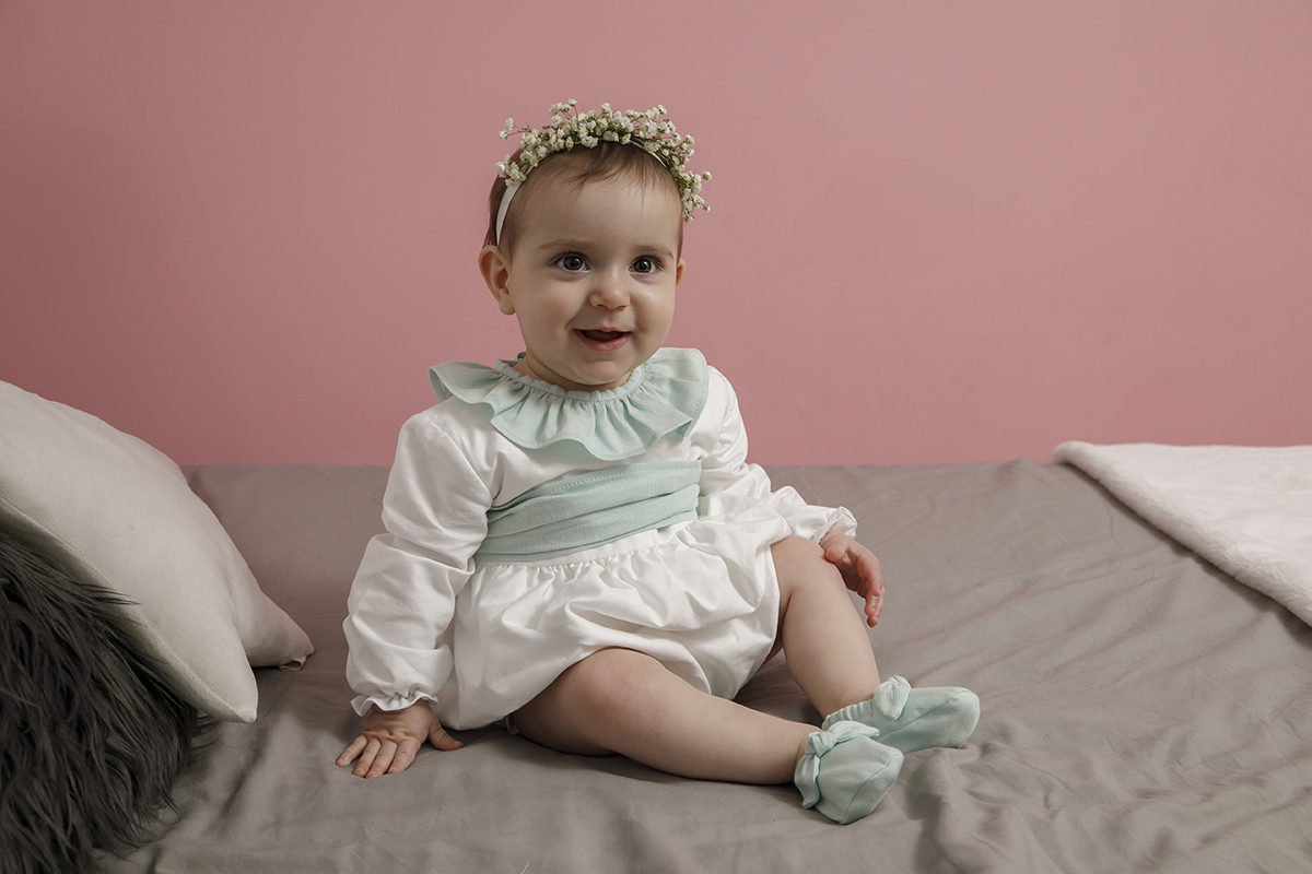 Num plano mais afastado, Valentina senta-se de corpo inteiro na cama. Uma mão pousa no colchão, a outra no joelho. O sorriso abre-se ao fotógrafo como se este captasse um pedacinho do seu coração.