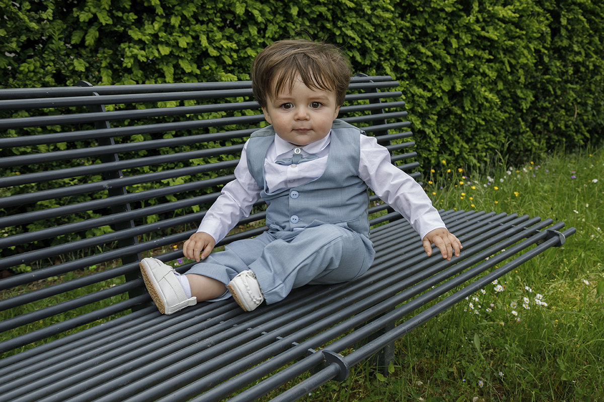 Num plano mais aberto, Lourenço continua no banco, agora com olhar mais sério. O corpo inteiro compõe-se com elegância, como se contemplasse a importância do momento.