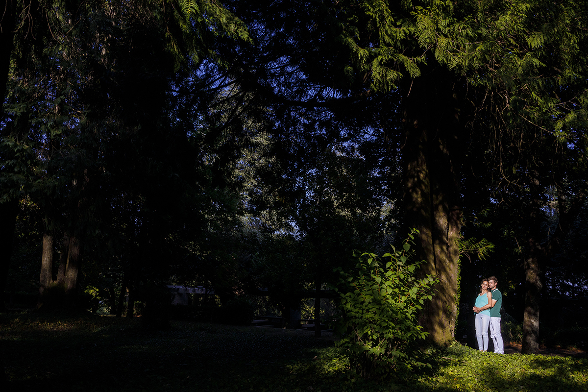 Num recanto banhado pela luz, os dois mantêm-se abraçados, com o olhar sereno, rodeados pela tranquilidade da natureza.