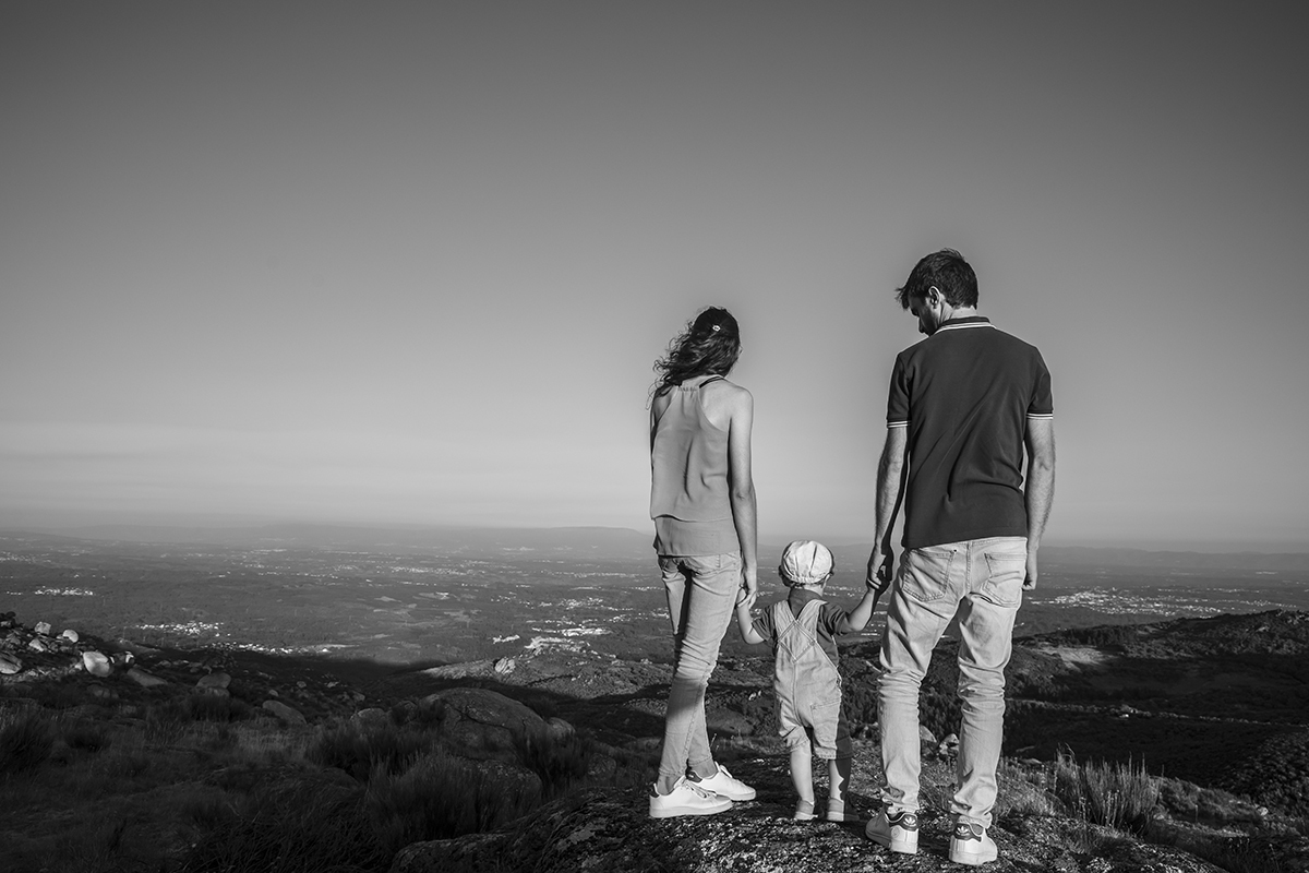 Em preto e branco, os três de pé, de mãos dadas, observam o horizonte. Tomé e Diana olham em frente, enquanto André se perde no olhar do filho.