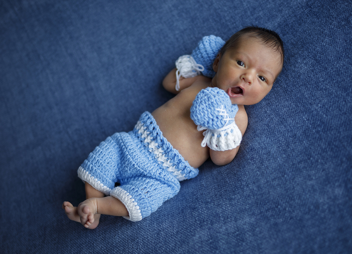 Com os pezinhos delicadamente cruzados, uma mão sobre o peito e outra junto à cabeça, Daniel boceja num momento irresistível de sono, uma imagem que transmite paz e doçura.