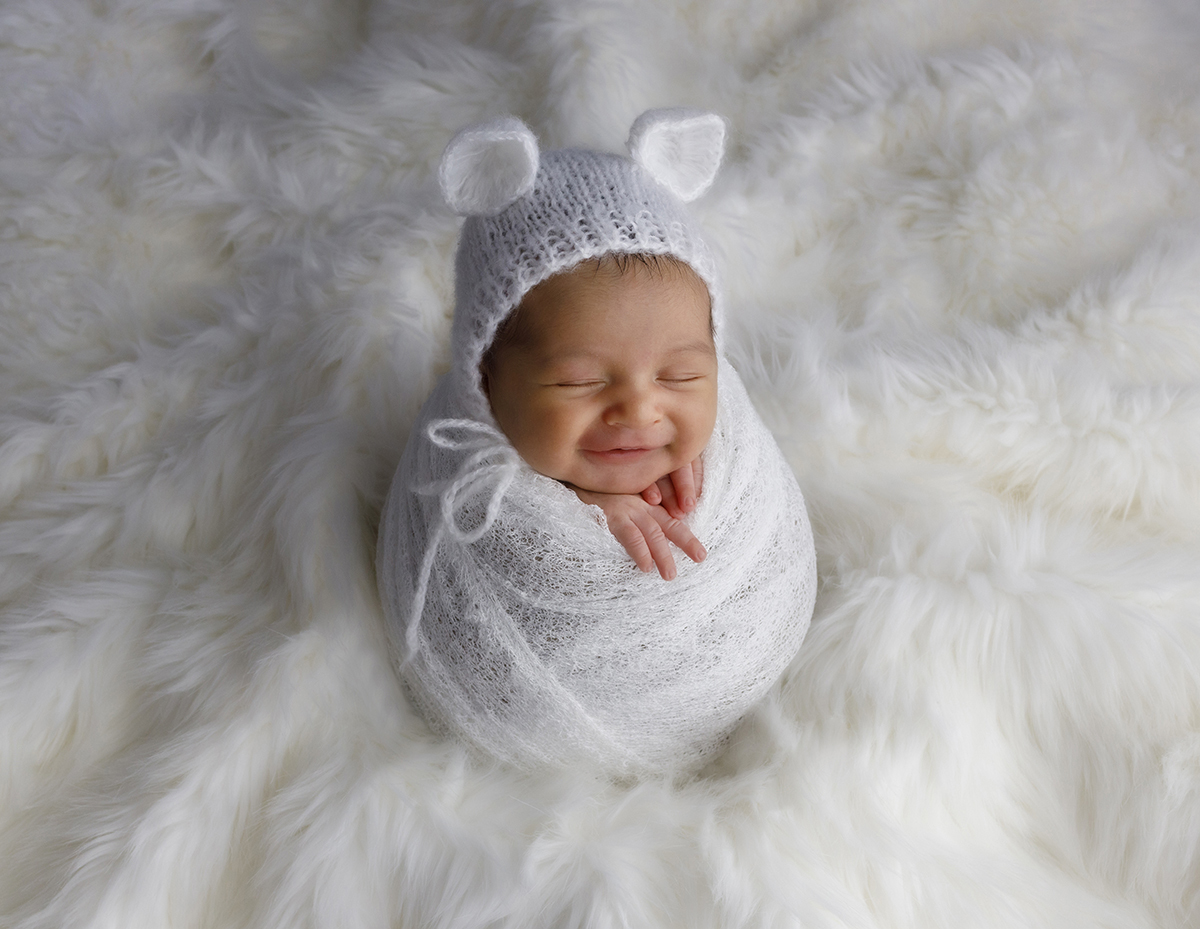 Numa fotografia verdadeiramente encantadora, Daniel aparece enrolado num lençol branco, sobre uma manta de pelinho, com um gorrinho de orelhas. O seu sorriso espontâneo faz desta foto um momento mágico e divertido.