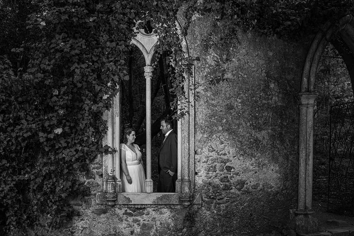 Num plano de detalhe, a ligação entre os dois revela-se nas mãos dadas. O vestido branco de Mónica e o fato azul de Ricardo contrastam com a textura rústica do cenário. As unhas laranja florescente da noiva acrescentam uma centelha vibrante à composição.