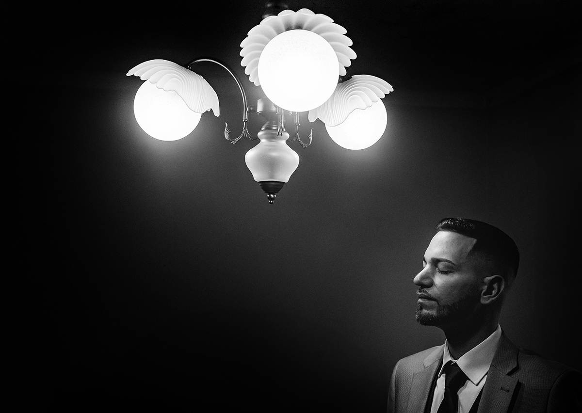 Numa composição a preto e branco, a luz do candeeiro desenha o seu perfil, refletindo a clareza de quem encontrou o seu caminho.