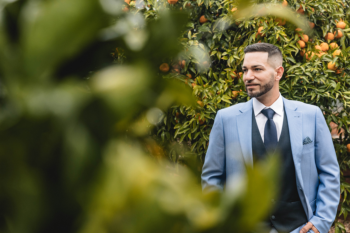Entre folhas de laranjeira, César posa contemplativo, envolto pela natureza e pela doçura do momento.
