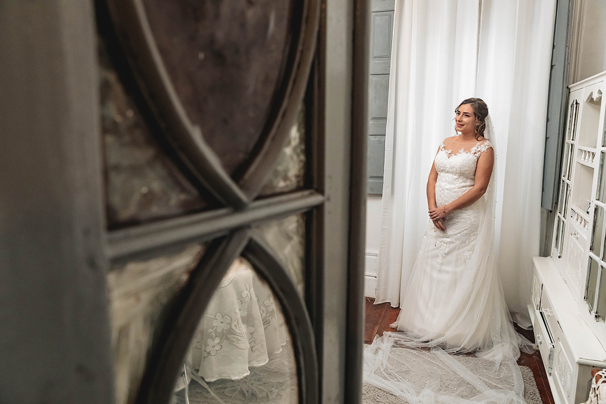 Frente à bela porta verde, Sandra, com véu a cair como cascata pelo tapete, sorri com a certeza de que este é o seu dia.