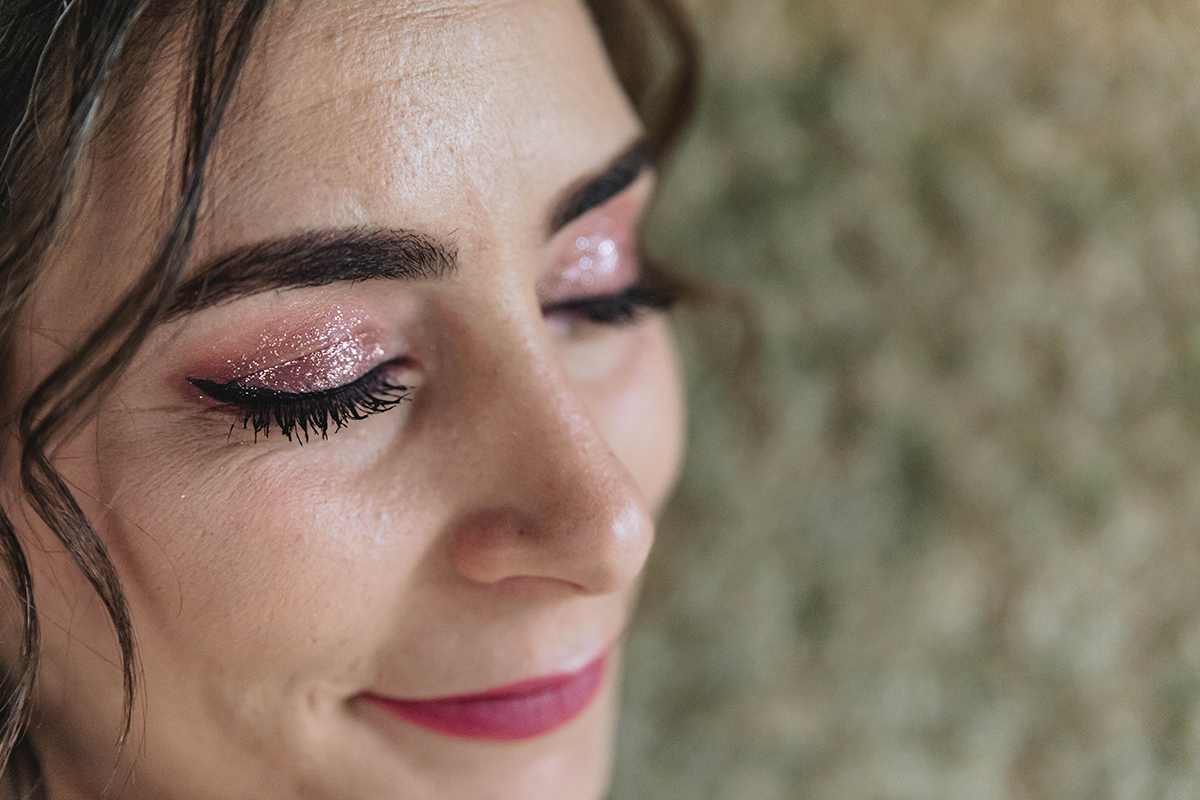 O detalhe do rosto, da maquilhagem em tons rosa, e dos cabelos ondulados revela uma beleza natural e delicada.