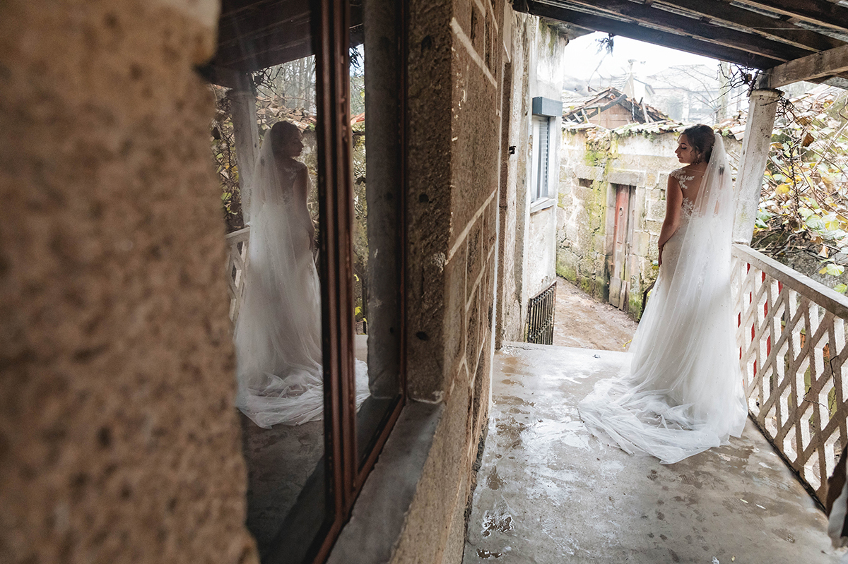 Com o véu esvoaçante e o vestido em destaque, Sandra posa de costas, enquanto o seu reflexo no espelho da janela parece sussurrar: 