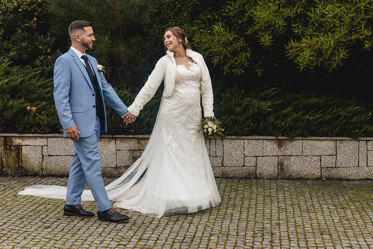 De mãos dadas, entre paralelos e natureza, caminham com sorrisos trocados e olhares que já dizem tudo.