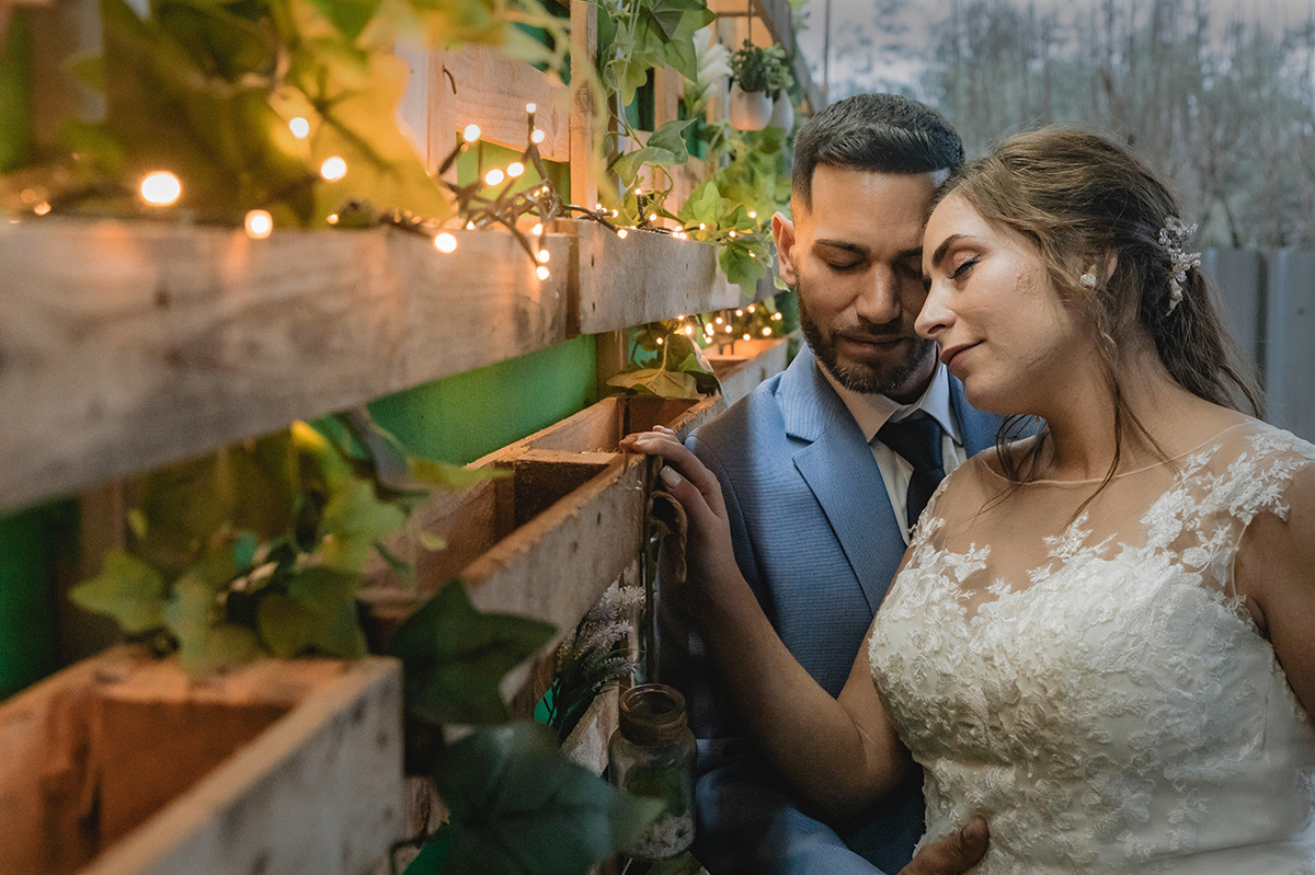 Encostados a uma parede de paletes com luzinhas, de olhos fechados, entregam-se ao silêncio, ao toque e à paz.