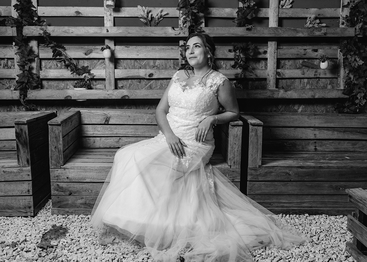 Sentada num banco de madeira, a noiva olha para o alto, como quem agradece ao céu por aquele amor.