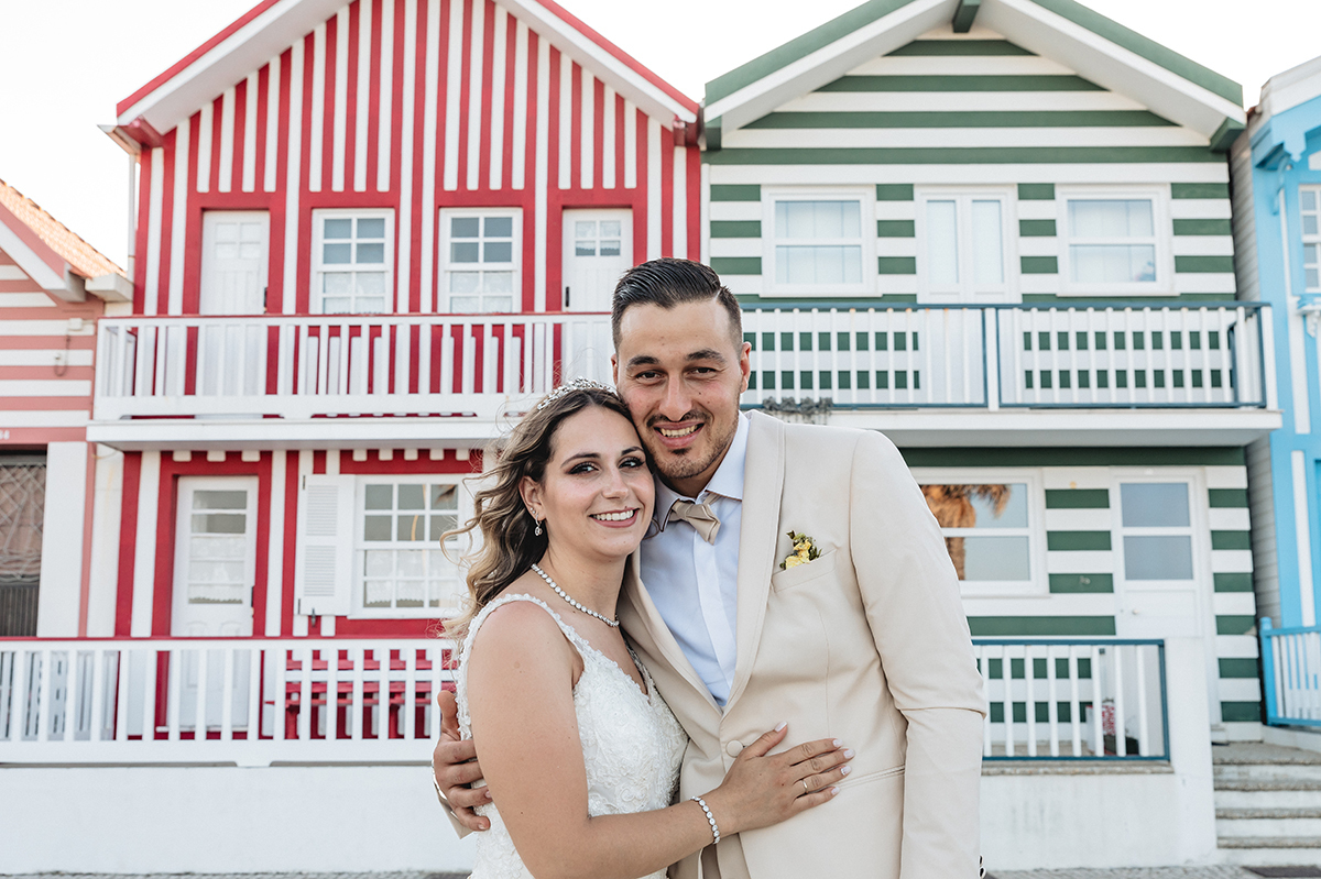 Os dois sorriem para a câmara de Ricardo Coimbra Fotografia. Ele envolve-a com um braço, e ela repousa a mão na barriga do Jorge, num gesto terno e carinhoso.