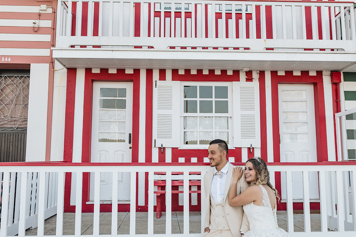 Com destaque para uma das casinhas vermelhas, vemos o casal a olhar com atenção e entusiasmo para algo fora de plano. O momento transparece felicidade.