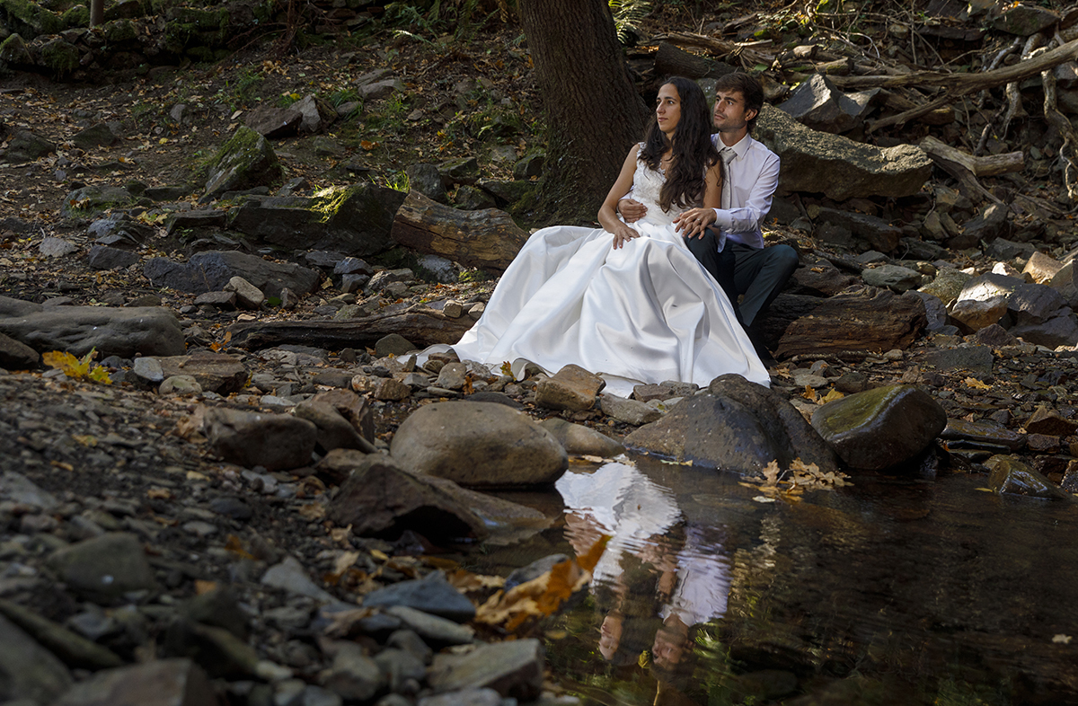 Mais perto do lago, Diana senta-se à frente de André, que a envolve com ternura. As mãos tocam-se num gesto simbólico de união e partilha.