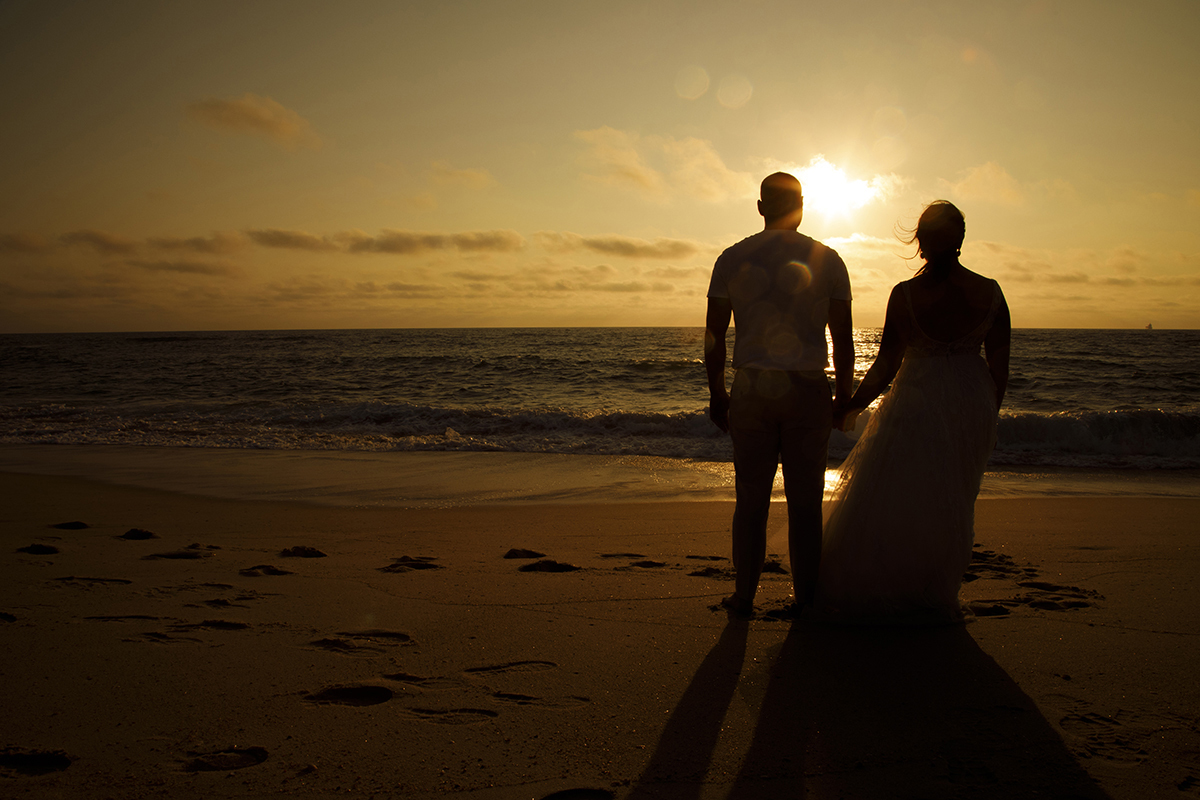Nesta fotografia também em silhueta, os dois estão lado a lado no lado direito da imagem, de costas para a câmara e de mãos dadas, a olhar o mar. O sol passa precisamente entre as suas cabeças, criando uma composição perfeita.
