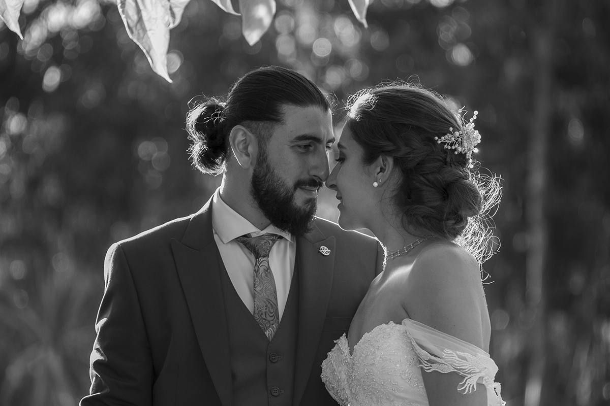 A preto e branco, os noivos estão prestes a beijar-se, ligados e apaixonados.