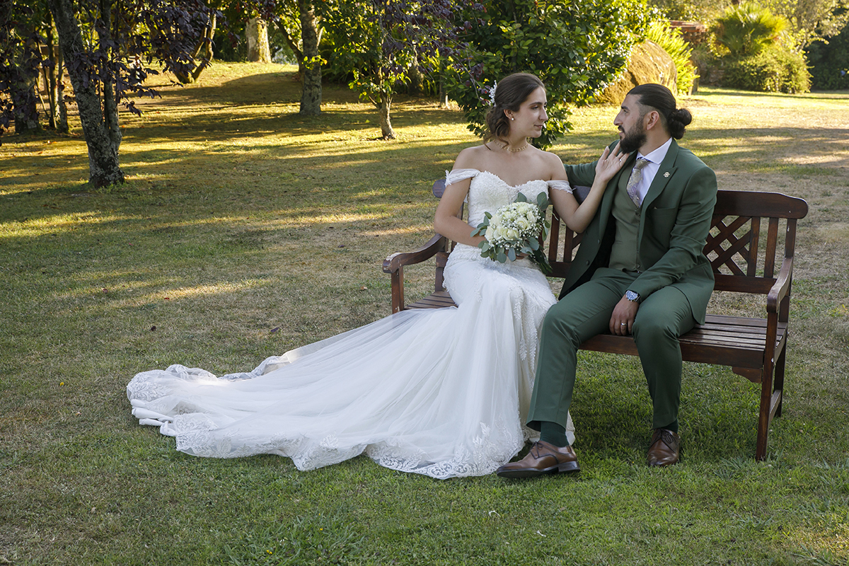 Sentados num banco, olham-se apaixonadamente, Carolina segura o bouquet e toca no ombro de Furkan.